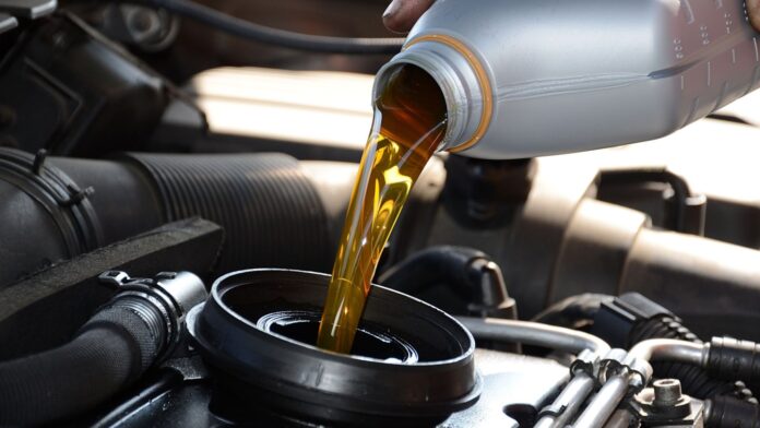 A person doing regular oil changes that are vital for engine health